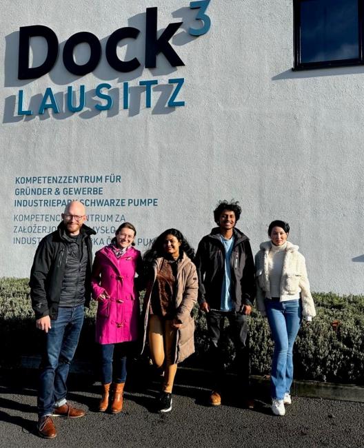 fem personer framför en skylt med Swarze Pumpe