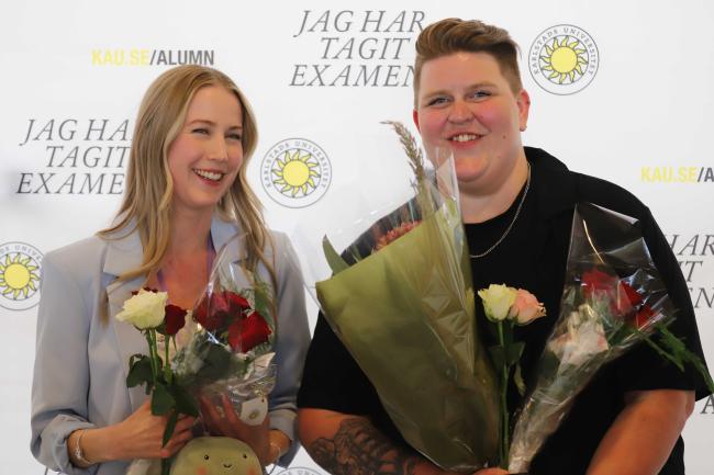 två studenter med blommor