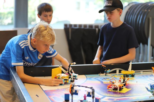 Robotkollo med en ljushårig pojke och två andra pojkar i bakgrunden