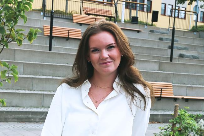 Kvinna utomhus med stentrappa i bakgrunden