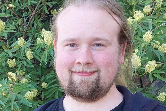 Man framför blommig buske