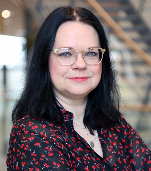 Kvinna i glasögon med trappa i bakgrunden