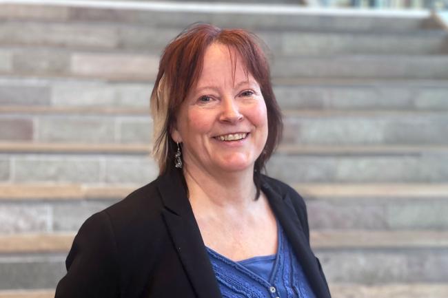 Kvinna inomhus framför stentrappa 