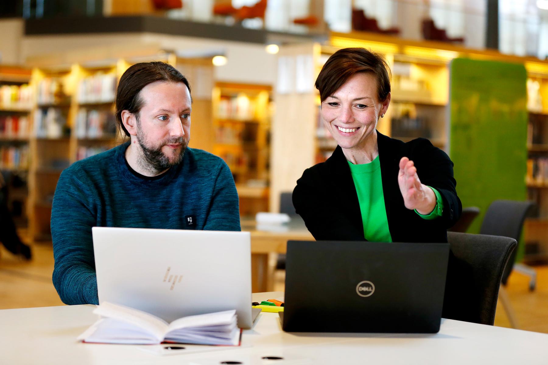 Evelina och Sebastian framför sina laptops.