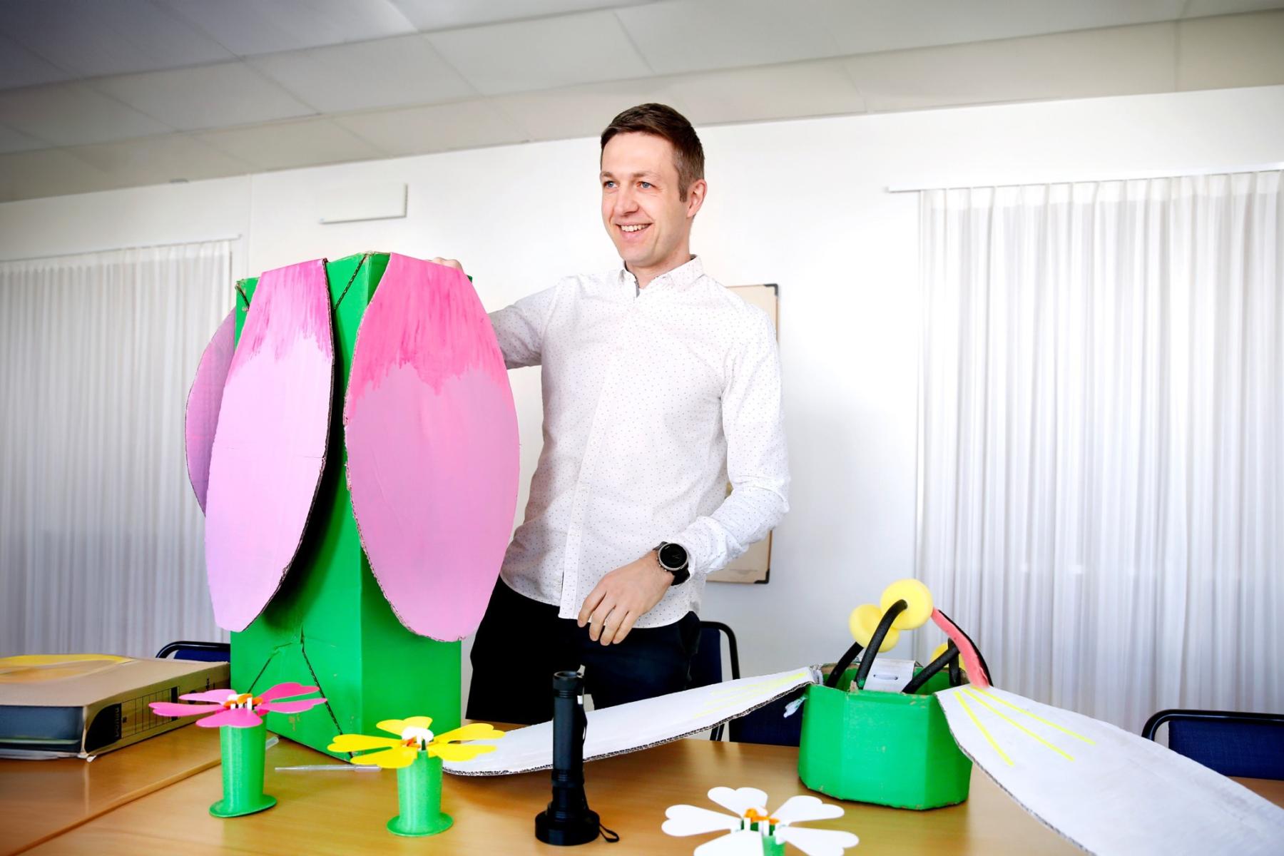 Peter Lampert demonstrerar färgglada modeller på ett bord.